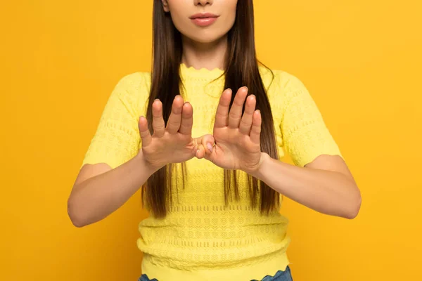 Vista recortada de la mujer usando lenguaje sordo y mudo sobre fondo amarillo - foto de stock