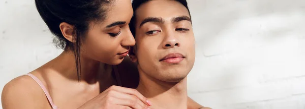 Mujer afroamericana abrazando novio en el dormitorio, plano panorámico - foto de stock