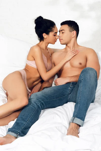 Africano americano mulher abraçando e beijando o homem na cama no quarto — Fotografia de Stock
