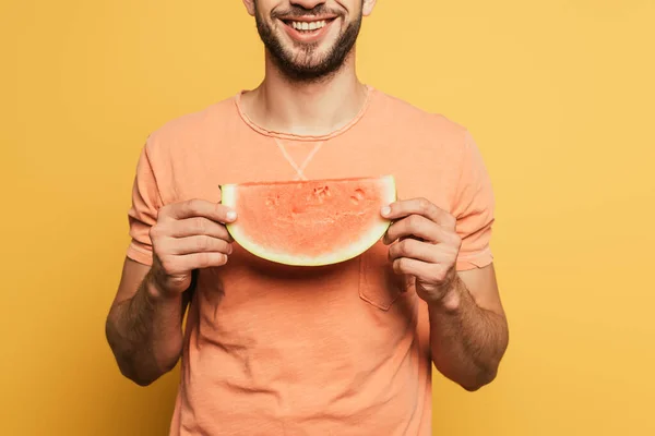 Cropped view of smiling man holding slice of ripe, juicy pineapple on yellow background — Stock Photo