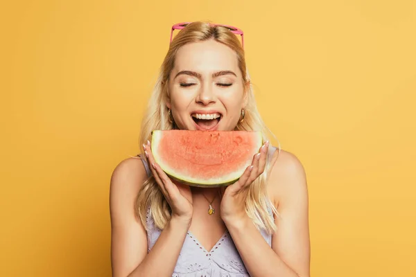 Linda, menina loira com olhos fechados comendo melancia suculenta no fundo amarelo — Fotografia de Stock