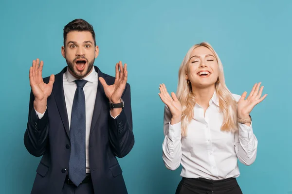Homme d'affaires excité et femme d'affaires montrant des gestes wow sur fond bleu — Photo de stock