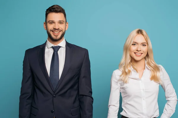 Jovem, casal sorridente de empresários olhando para câmera isolada em azul — Fotografia de Stock