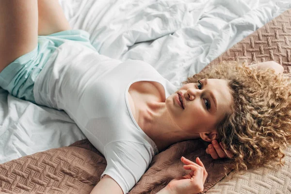 Приваблива дівчина в домашньому одязі лежить на ліжку вранці — стокове фото
