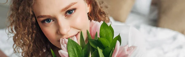 Attractive girl holding tulips in morning, horizontal image — Stock Photo