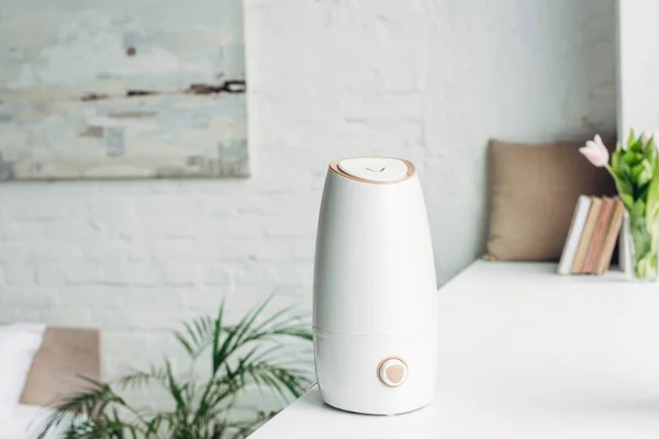 Humidificateur blanc debout sur le rebord de la fenêtre à la maison — Photo de stock