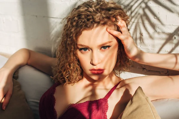 Passionate girl in red sexy lingerie in bedroom with sunlight and shadows — Stock Photo