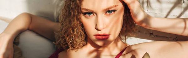Atraente sexy curly menina no vermelho lingerie no quarto com luz solar e sombras, conceito horizontal — Fotografia de Stock