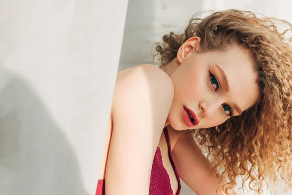 Attraente ragazza riccia in lingerie sexy rossa con luce solare — Foto stock