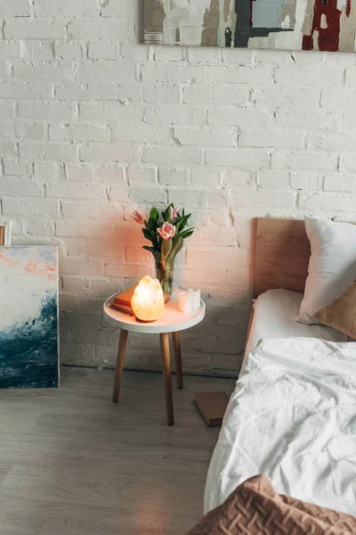 Intérieur de la chambre avec lampe au sel naturel, fleurs et peintures — Photo de stock