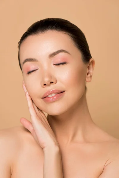 Beautiful tender asian girl with clean face and closed eyes isolated on beige — Stock Photo