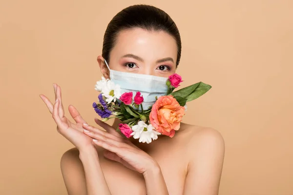 Attractive tender naked asian woman in floral face mask isolated on beige — Stock Photo