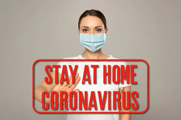 Woman in medical mask showing stop gesture isolated on grey, stay at home and coronavirus illustration — Stock Photo