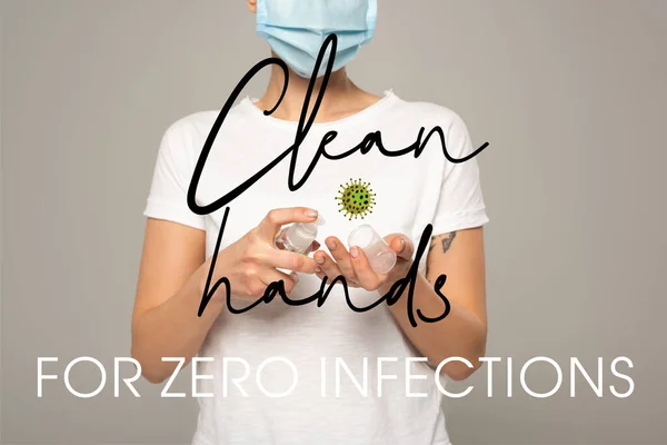 Vista recortada de la mujer en máscara médica usando desinfectante de manos aislado en gris, manos limpias para cero infecciones ilustración - foto de stock