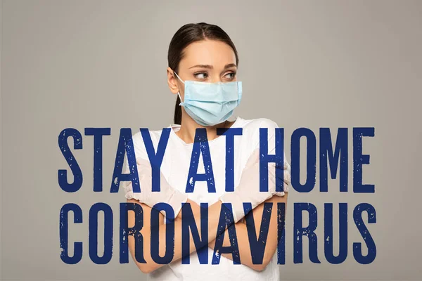 Mujer joven con máscara médica y guantes de látex mirando hacia otro lado aislado en gris, quedarse en casa y coronavirus ilustración - foto de stock