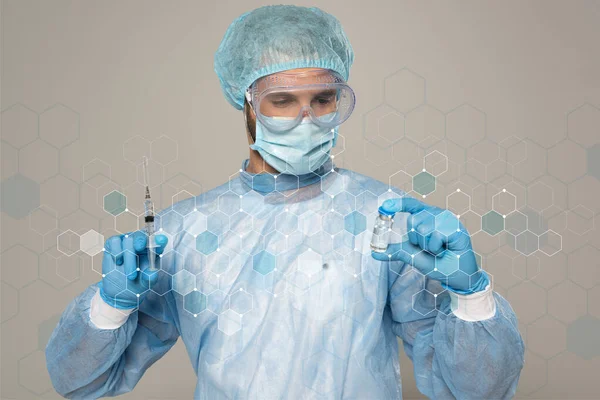 Médico en máscara médica y googles protectores sosteniendo frasco de vacuna y jeringa aislados en gris, ilustración de células - foto de stock