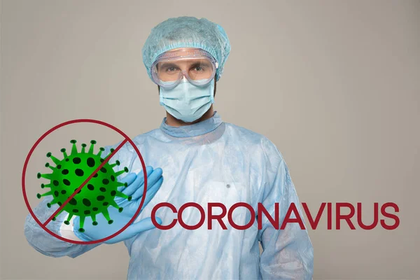 Doctor en máscara médica que muestra el gesto de parada en la cámara aislada en gris, bacterias y coronavirus ilustración - foto de stock