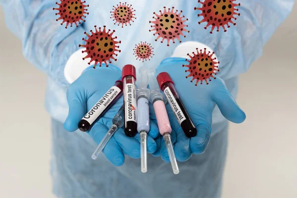 Cropped view of doctor holding test tubes with blood samples and coronavirus lettering and syringes isolated on grey, bacteria illustration — Stock Photo