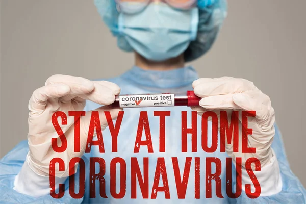 Selective focus of doctor holding test tube with blood sample of coronavirus lettering isolated on grey, stay at home coronavirus illustration — Stock Photo