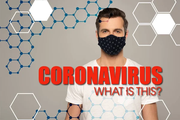 Человек в защитной маске смотрит на камеру, изолированную на сером коронавирусе. Что это за иллюстрация? — стоковое фото