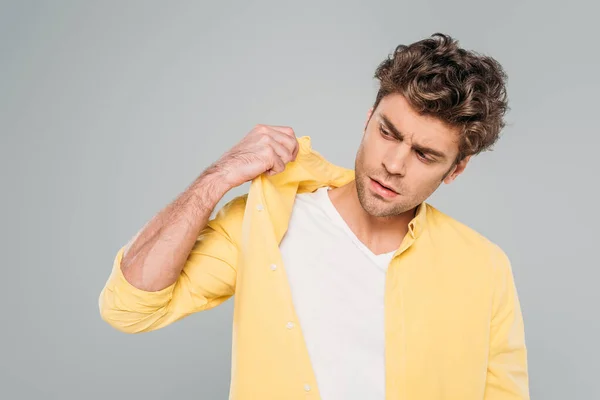Homme inquiet touchant chemise isolée sur gris — Photo de stock