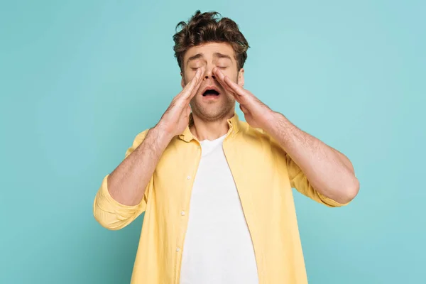 Front view of man sneezing isolated on blue — Stock Photo