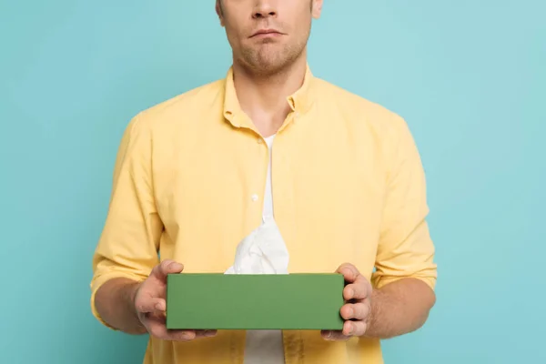 Vue recadrée de l'homme tenant boîte avec des serviettes isolées sur bleu — Photo de stock