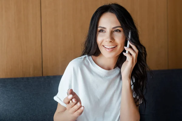 Fröhliche junge Frau plaudert zu Hause auf dem Smartphone — Stockfoto