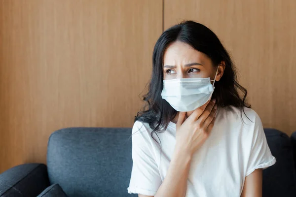 Femme malade dans le masque médical assis à la maison sur l'isolement personnel — Photo de stock