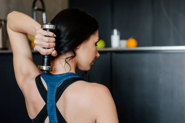 Vue arrière de l'entraînement de femme athlétique avec haltère à la maison — Photo de stock