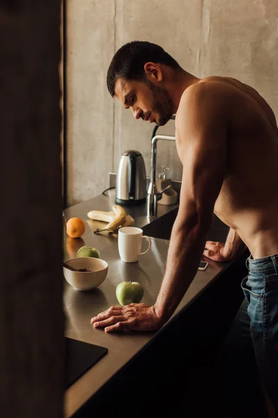 Selective focus of bearded man standing near table with fruits — Stock Photo