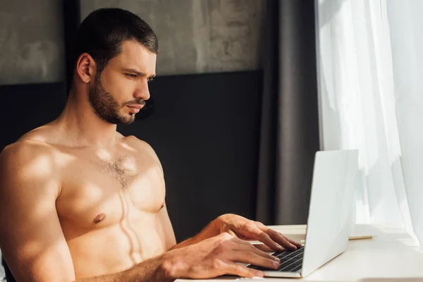 Bearded and shirtless freelancer using laptop at home — Stock Photo