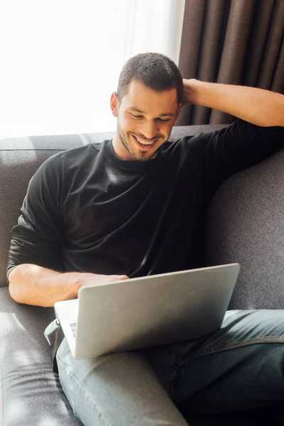 Freelancer barbudo e feliz usando laptop em casa — Fotografia de Stock