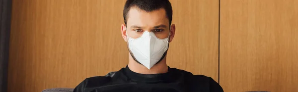 La cosecha panorámica del hombre en la máscara médica en casa - foto de stock