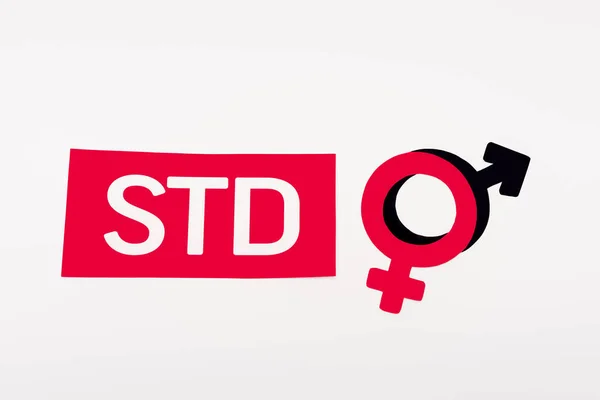 Top view of gender symbols near paper with std lettering isolated on white — Stock Photo