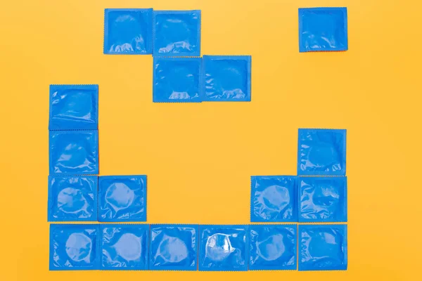 Vue de dessus des packs bleus avec préservatifs isolés sur orange — Photo de stock