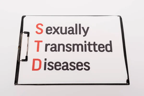 Top view of clipboard with sexually transmitted diseases lettering isolated on white — Stock Photo