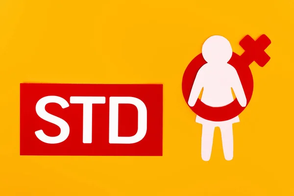 Top view of paper person with male gender symbol near std lettering isolated on orange — Stock Photo