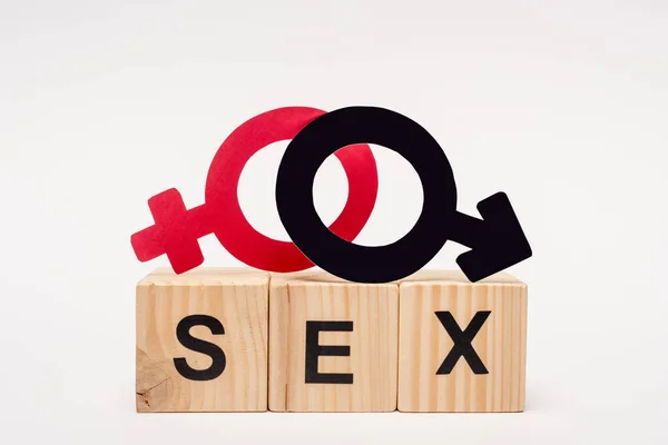 Wooden cubes with sex lettering near gender symbols on white — Stock Photo