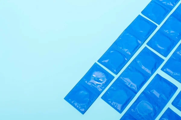 Top view of packs with condoms isolated on blue with copy space — Stock Photo