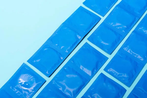 Embalagens com preservativos contraceptivos isolados em azul com espaço de cópia — Fotografia de Stock