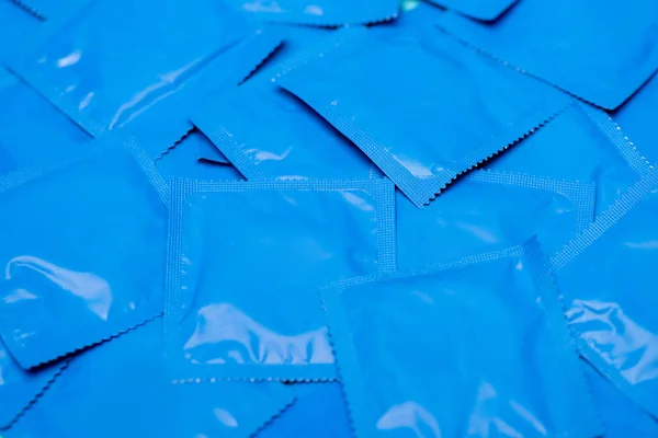 Primer plano de paquetes azules con condones - foto de stock