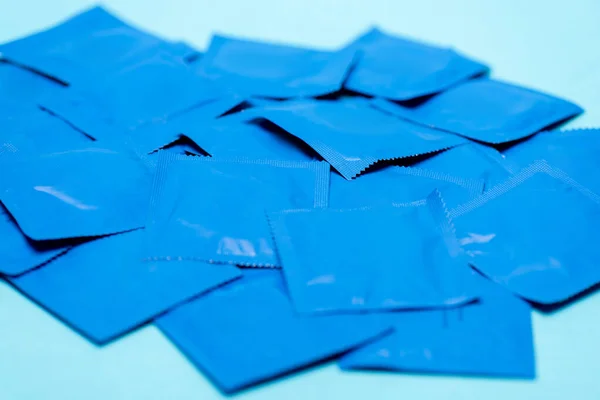 Foco seletivo de embalagens com preservativos isolados em azul — Fotografia de Stock