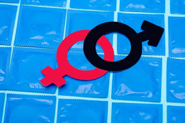 Símbolos de gênero em preservativos isolados em azul — Fotografia de Stock