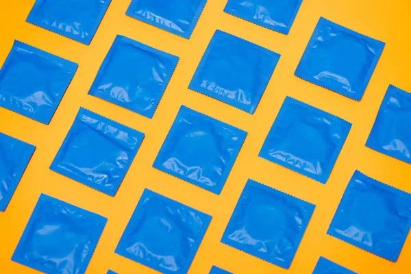 Top view of blue packs with condoms isolated on orange — Stock Photo