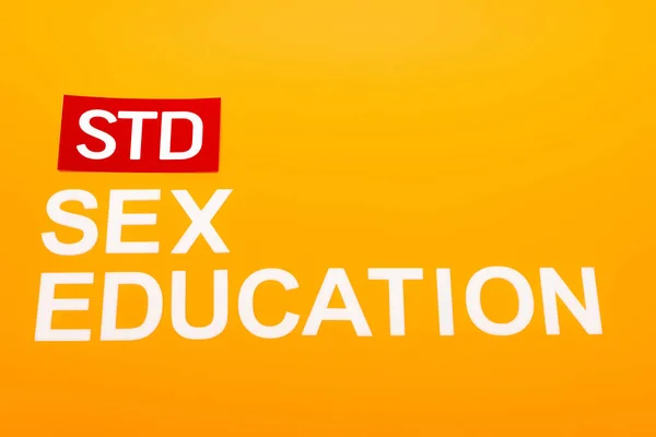 Top view of sex education and std lettering isolated on orange — Stock Photo