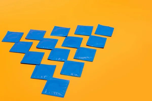 Flat lay with condoms in packs isolated on orange — Stock Photo