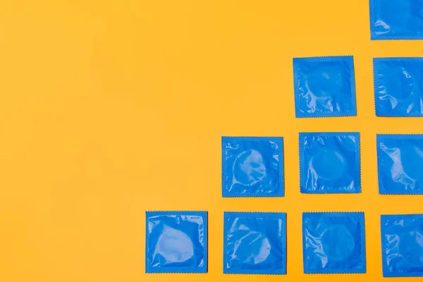 Top view of condoms isolated on orange with copy space — Stock Photo