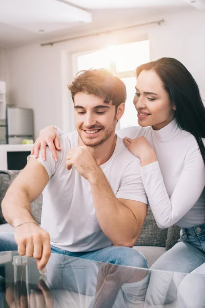 Beautiful smiling couple throwing coin during self isolation at home — Stock Photo