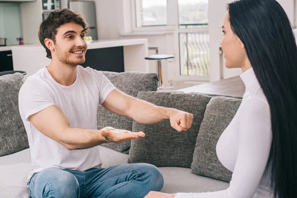 Beautiful woman choosing one on male hands during self isolation at home — Stock Photo